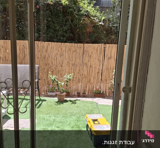חלון זכוכית עם נוף לגינה ירוקה